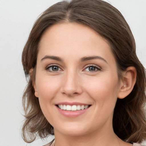 Joyful white young-adult female with medium  brown hair and grey eyes