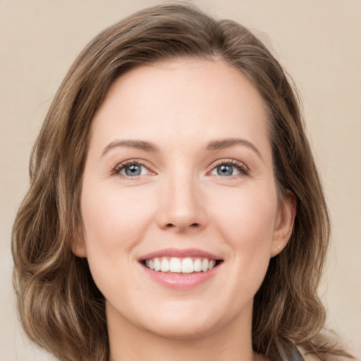 Joyful white young-adult female with medium  brown hair and green eyes