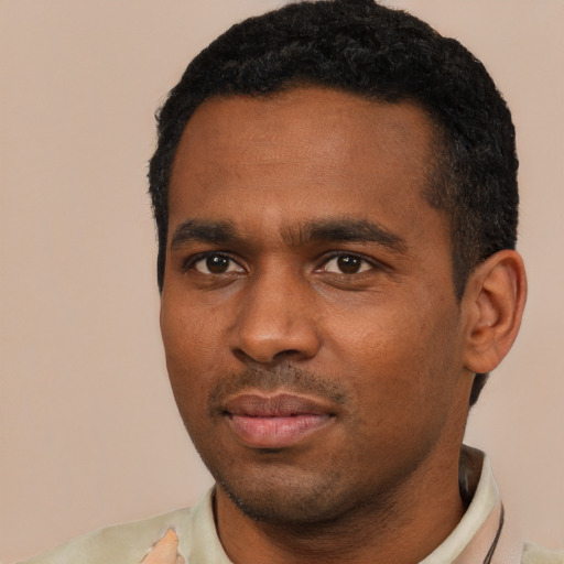 Joyful black young-adult male with short  black hair and brown eyes