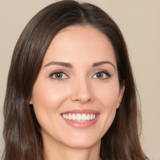 Joyful white young-adult female with long  brown hair and brown eyes