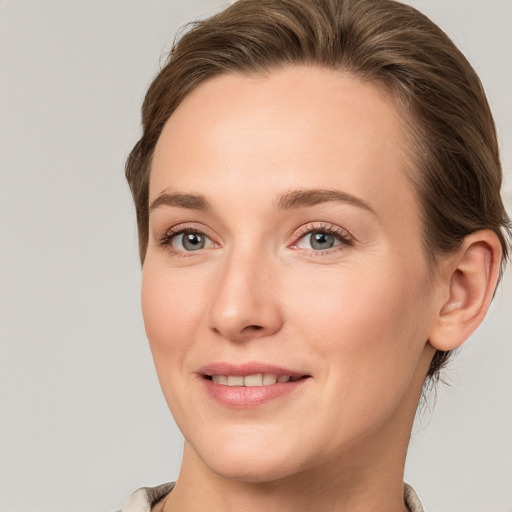 Joyful white young-adult female with medium  brown hair and grey eyes