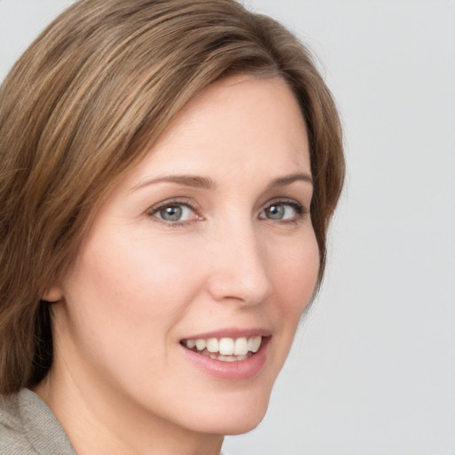 Joyful white young-adult female with medium  brown hair and green eyes