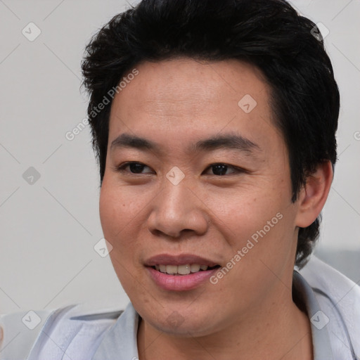 Joyful asian young-adult male with short  black hair and brown eyes