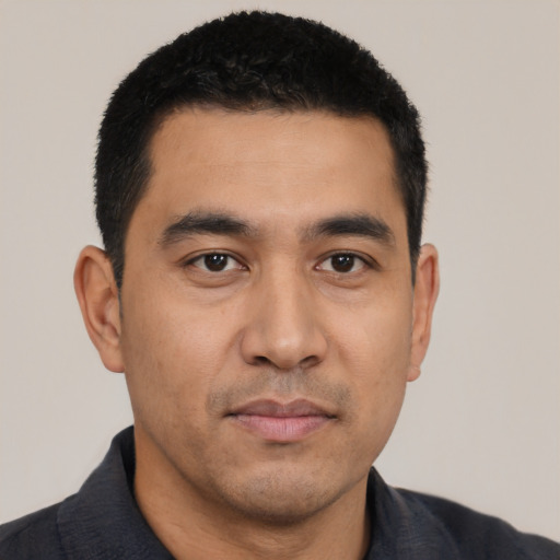 Joyful latino young-adult male with short  black hair and brown eyes