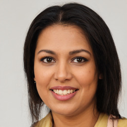 Joyful latino young-adult female with medium  brown hair and brown eyes