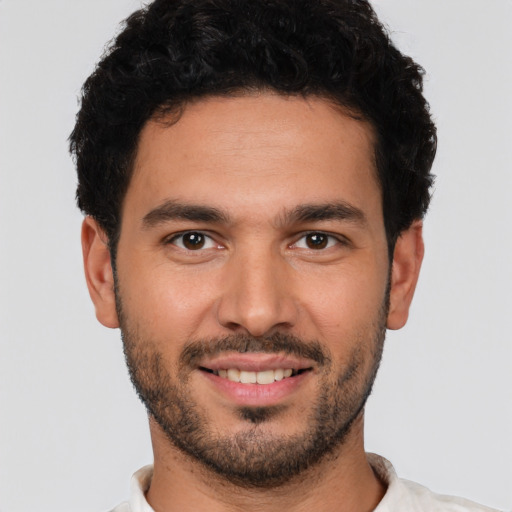 Joyful white young-adult male with short  black hair and brown eyes