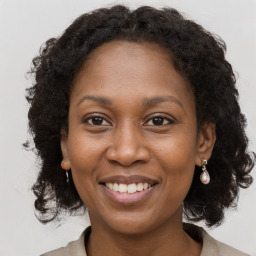 Joyful black adult female with medium  brown hair and brown eyes