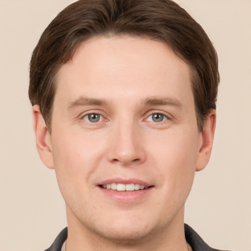 Joyful white young-adult male with short  brown hair and grey eyes