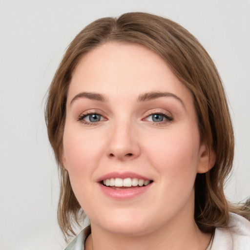 Joyful white young-adult female with medium  brown hair and green eyes