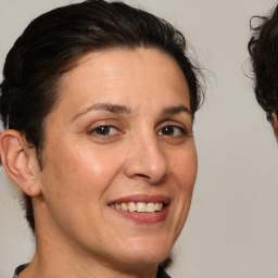 Joyful white adult female with medium  brown hair and brown eyes