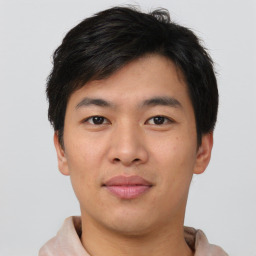 Joyful asian young-adult male with short  brown hair and brown eyes