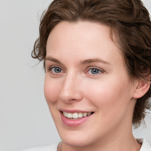 Joyful white young-adult female with medium  brown hair and green eyes