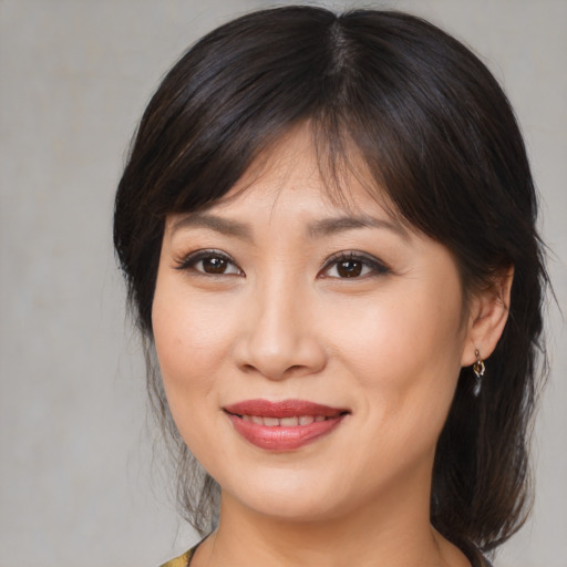 Joyful asian young-adult female with medium  brown hair and brown eyes