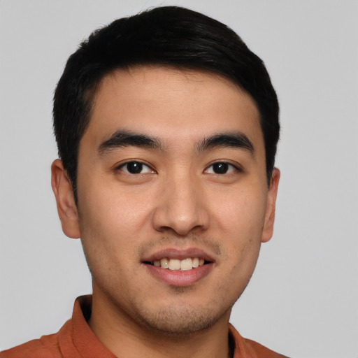 Joyful asian young-adult male with short  brown hair and brown eyes