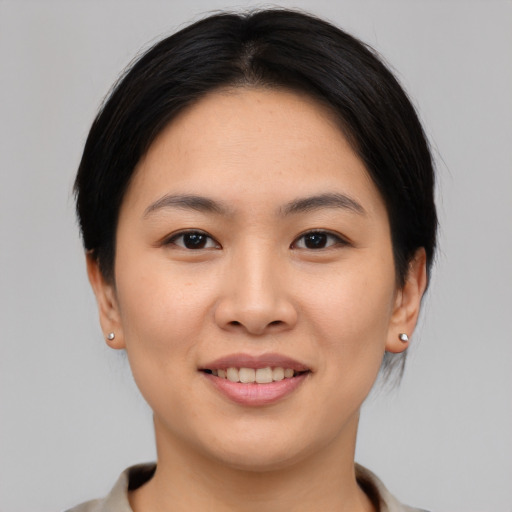 Joyful asian young-adult female with short  brown hair and brown eyes