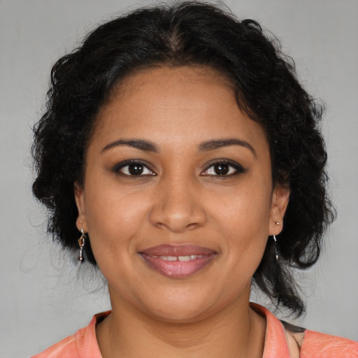 Joyful black young-adult female with medium  brown hair and brown eyes