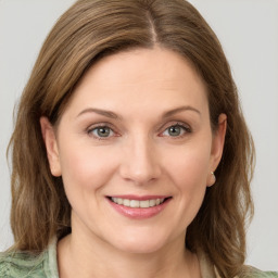 Joyful white young-adult female with medium  brown hair and green eyes