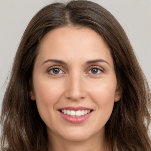 Joyful white young-adult female with long  brown hair and brown eyes