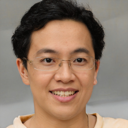 Joyful asian adult male with short  brown hair and brown eyes