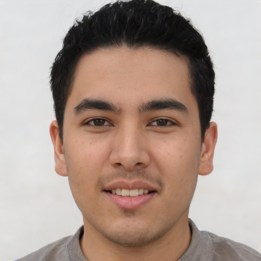 Joyful latino young-adult male with short  brown hair and brown eyes