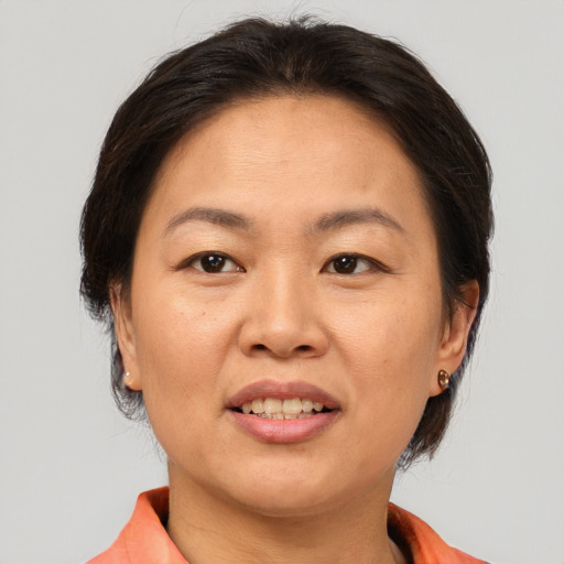 Joyful asian adult female with medium  brown hair and brown eyes
