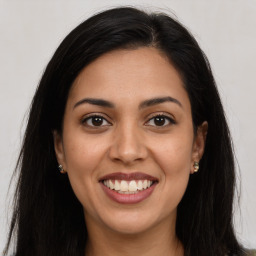 Joyful latino young-adult female with long  brown hair and brown eyes