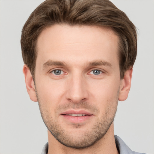 Joyful white young-adult male with short  brown hair and grey eyes