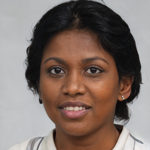 Joyful black young-adult female with medium  brown hair and brown eyes
