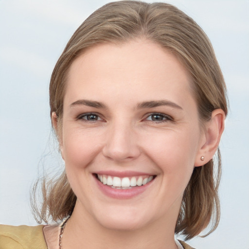 Joyful white young-adult female with medium  brown hair and grey eyes