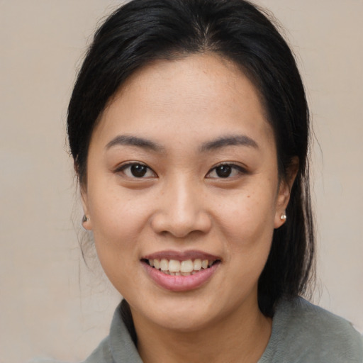 Joyful asian young-adult female with medium  black hair and brown eyes