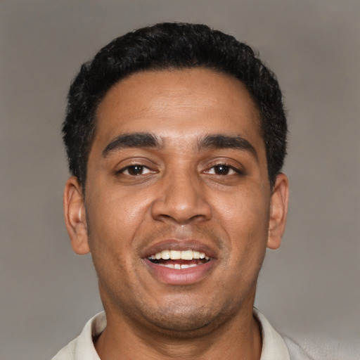 Joyful black young-adult male with short  black hair and brown eyes