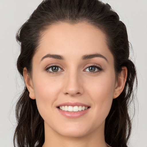 Joyful white young-adult female with long  brown hair and brown eyes