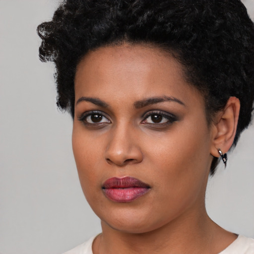 Joyful black young-adult female with short  black hair and brown eyes