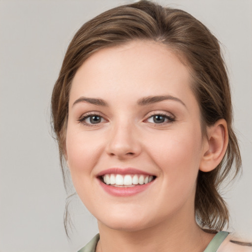 Joyful white young-adult female with medium  brown hair and green eyes