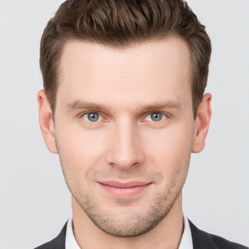 Joyful white young-adult male with short  brown hair and grey eyes