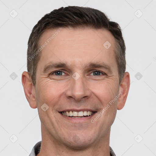 Joyful white adult male with short  brown hair and brown eyes