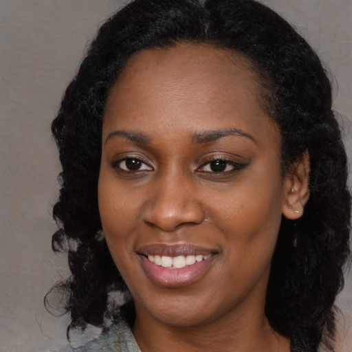 Joyful black young-adult female with long  black hair and brown eyes