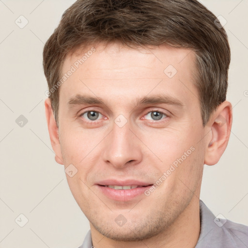 Joyful white young-adult male with short  brown hair and grey eyes