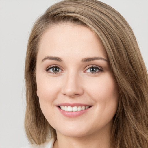 Joyful white young-adult female with long  brown hair and green eyes