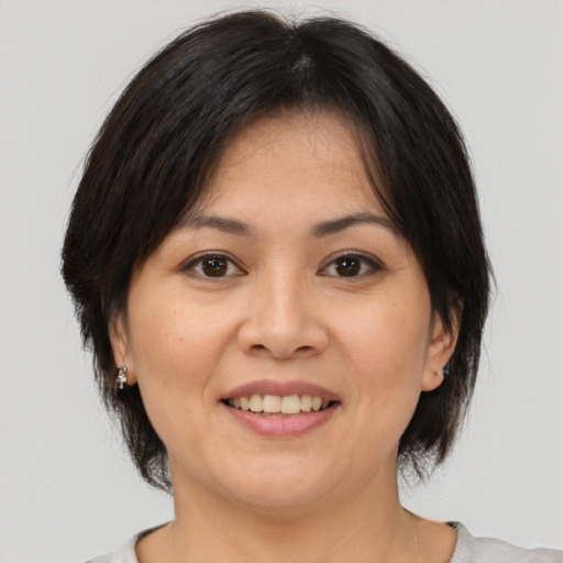 Joyful asian adult female with medium  brown hair and brown eyes