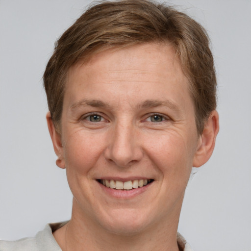 Joyful white adult female with short  brown hair and grey eyes