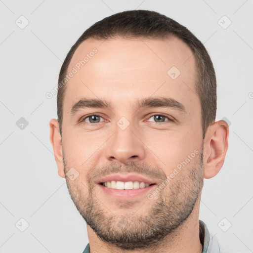 Joyful white young-adult male with short  brown hair and brown eyes