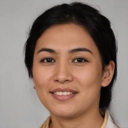 Joyful latino young-adult female with medium  brown hair and brown eyes