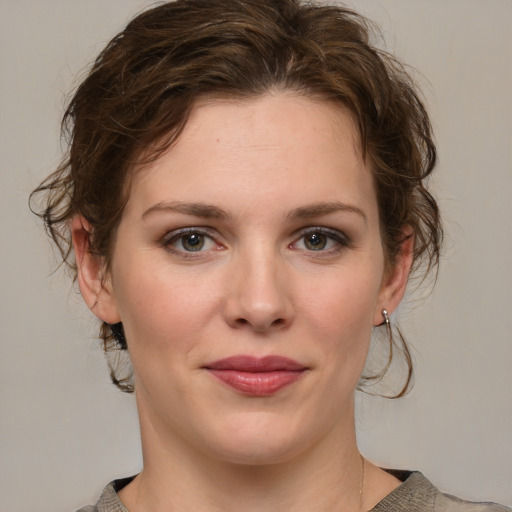 Joyful white young-adult female with medium  brown hair and green eyes