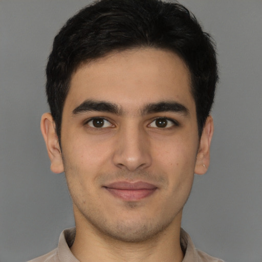 Joyful latino young-adult male with short  brown hair and brown eyes