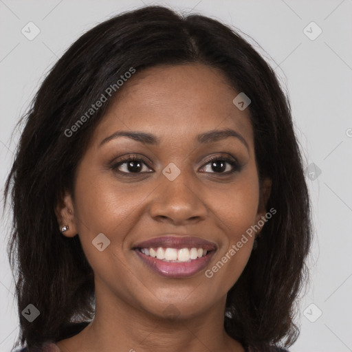 Joyful black young-adult female with long  brown hair and brown eyes