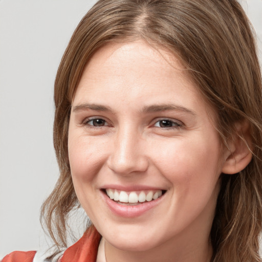 Joyful white young-adult female with medium  brown hair and grey eyes