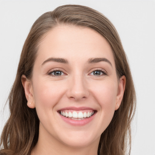 Joyful white young-adult female with long  brown hair and grey eyes