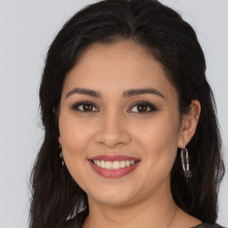 Joyful latino young-adult female with long  brown hair and brown eyes