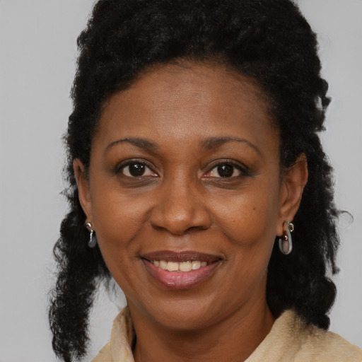 Joyful black adult female with medium  brown hair and brown eyes